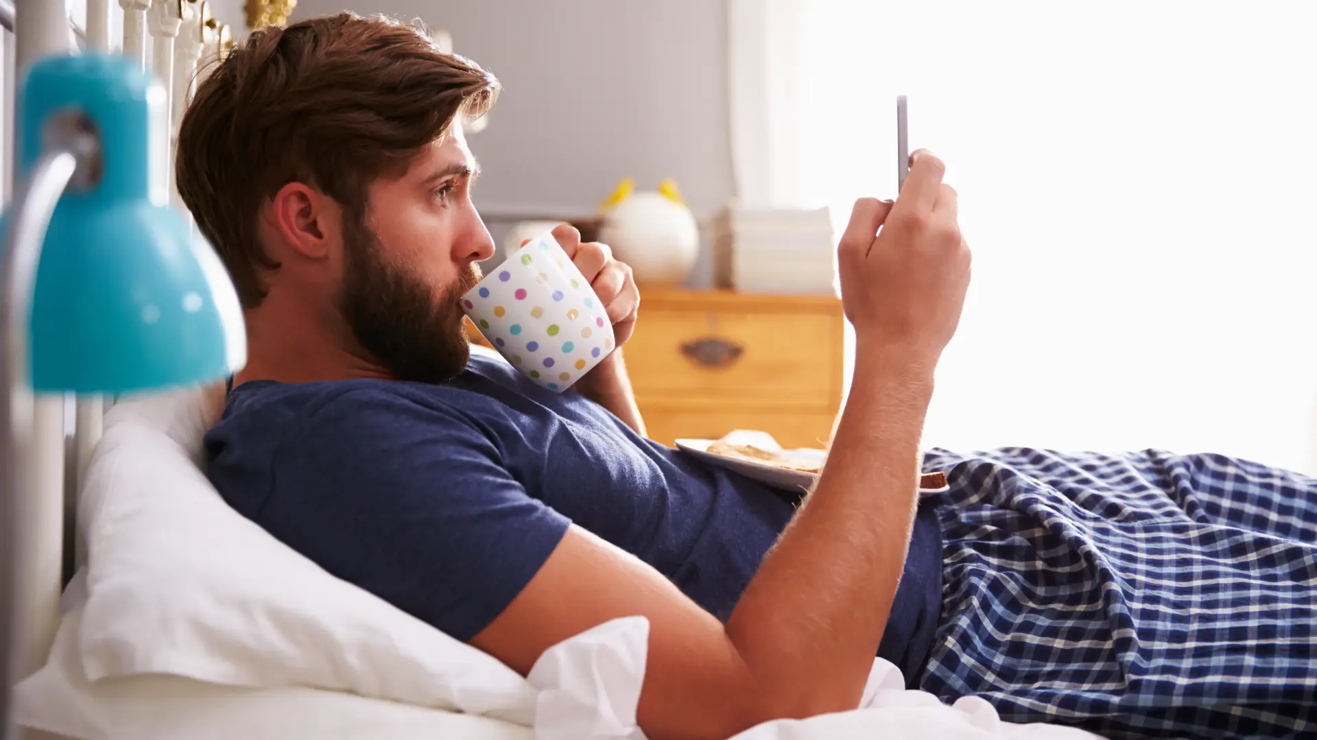 shutterstock_265630247 kafa telefon muškarac krevet buđenje jutro jutarnja navika rutina čaj odmor opuštanje-680f6443bb6a4.webp