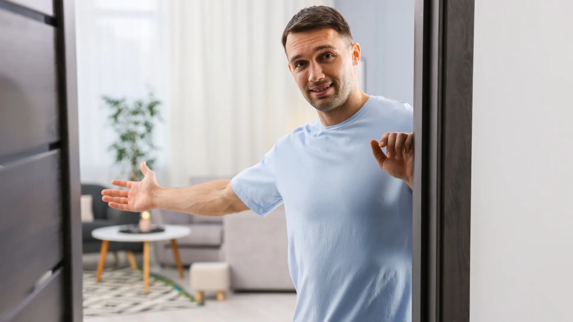 shutterstock_2616406457 muškarac kuća dom stan enterijer dnevna soba dobrodošli vrata ulaz u stan wlcome-69be8dbdb12c1.webp