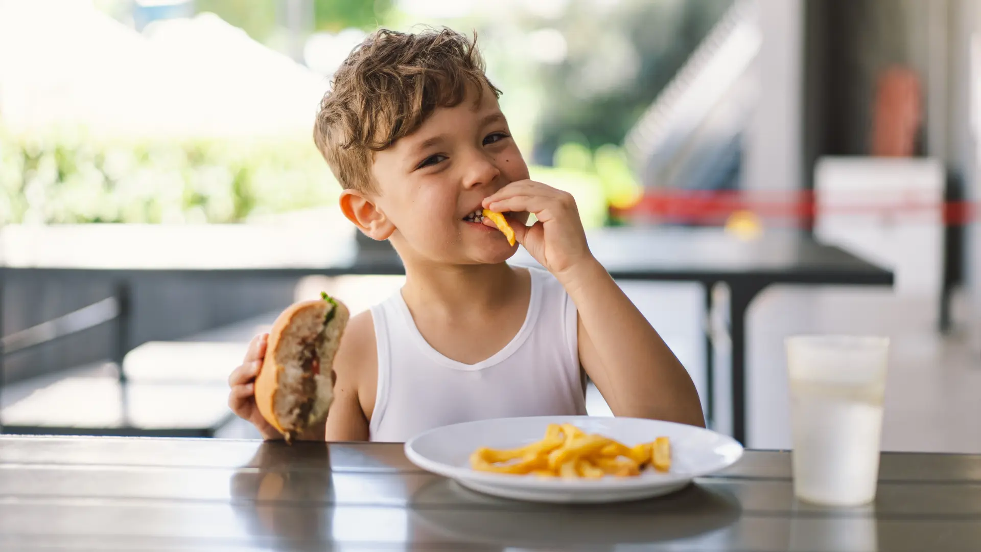 shutterstock_2449738805 dete dečak nezdrava brza hrana pržena pomfrir burger-6aa90be0adaa0.webp